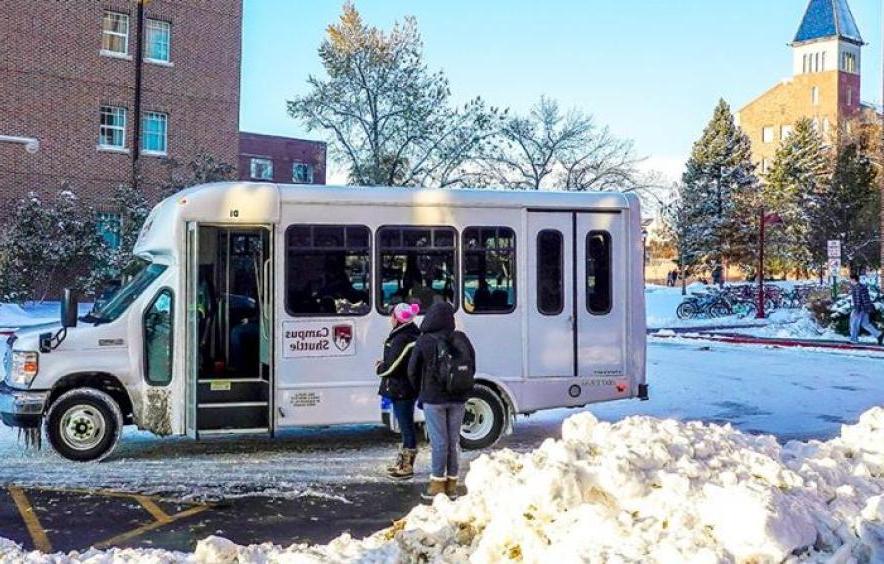 students getting onto the campus shuttle on a snowy morning